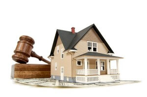 Home, money and gavel real estate concept; isolated on white with shallow depth of field